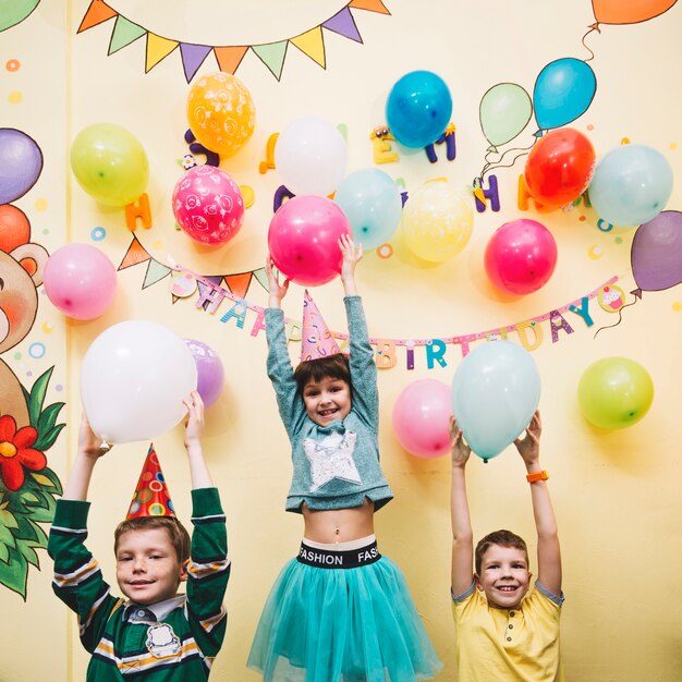 Cheerful kids holding balloons