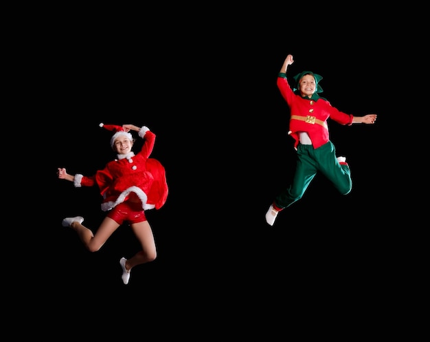 Free photo cheerful kids - a young girl wearing a santa's costume and boy wearing elf costume flying together