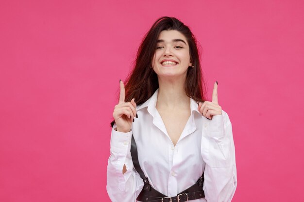 Cheerful lady pointing her fingers up and smiling to the camera