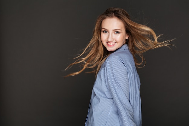 Free photo cheerful lady posing over dark wall