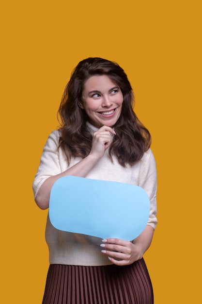 Cheerful lady with a colorful cardboard tablet looking aside