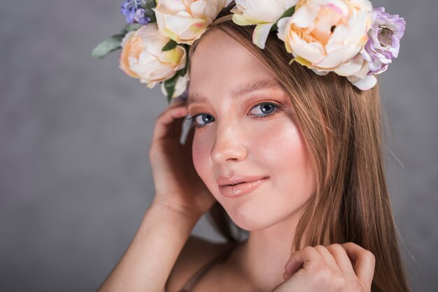 頭の上の花を持つ陽気な女性