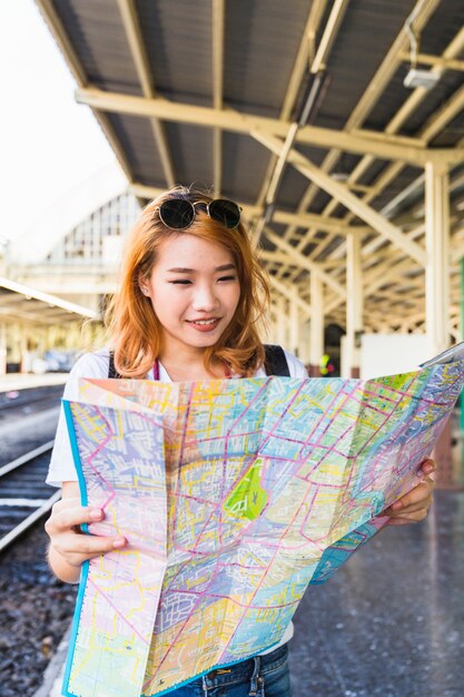 Cheerful lady with map on platform