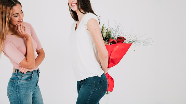 Cheerful lesbian couple with bouquet