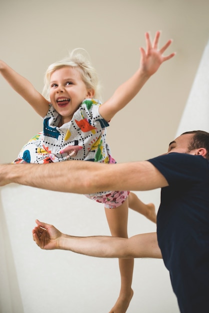 Free photo cheerful little girl playing with her father