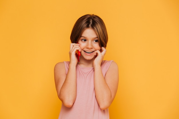 Cheerful little lady talking on phone isolated