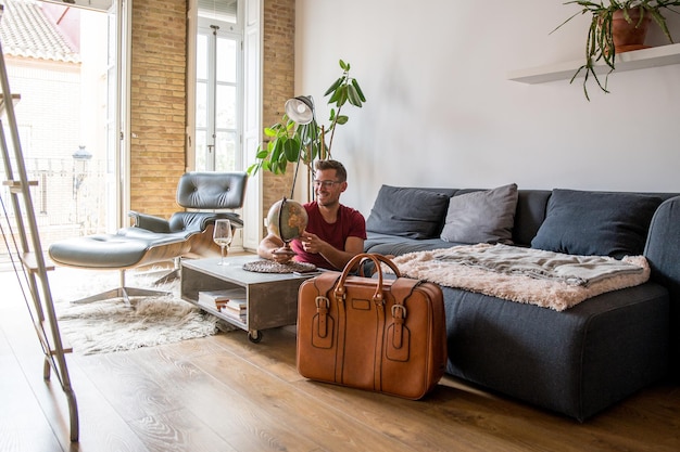 Cheerful male traveler with Earth globe