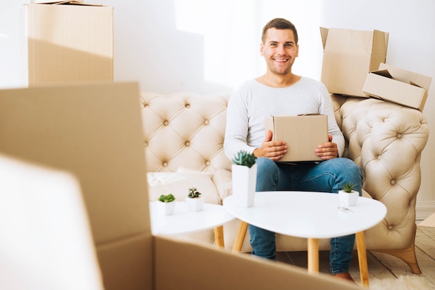 Cheerful man in apartment with boxes