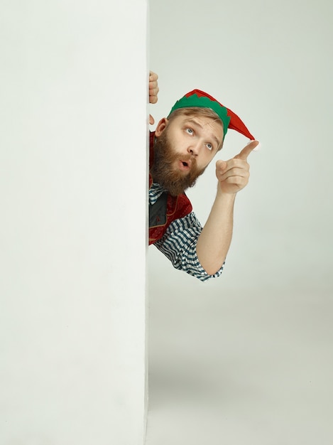 Uomo allegro in costume da elfo che indica qualcosa con il dito