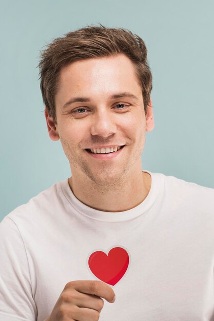 Cheerful man holding a heart icon