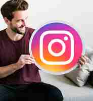 Free photo cheerful man holding an instagram icon