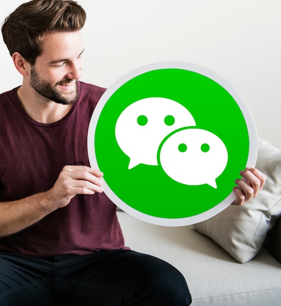 Foto gratuita uomo allegro che tiene un'icona di wechat