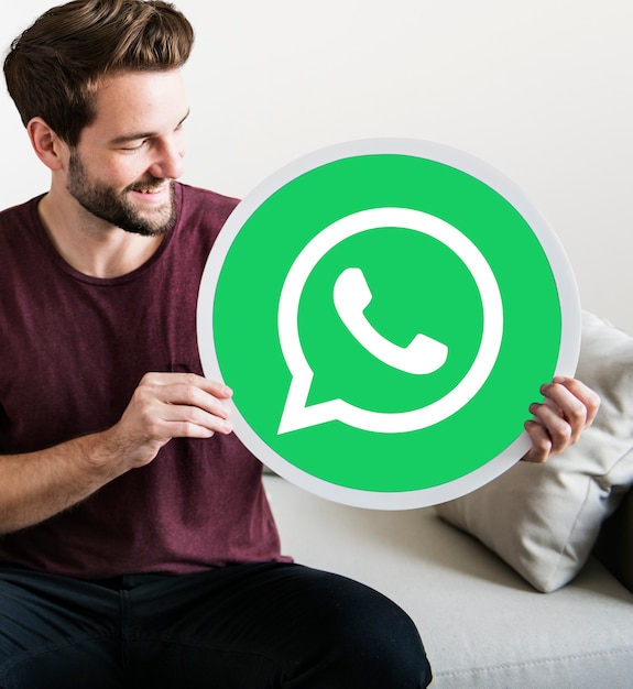 Foto gratuita uomo allegro che tiene un'icona di whatsapp messenger