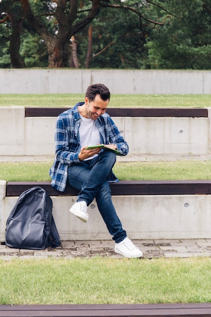 Free photo cheerful man reading in park