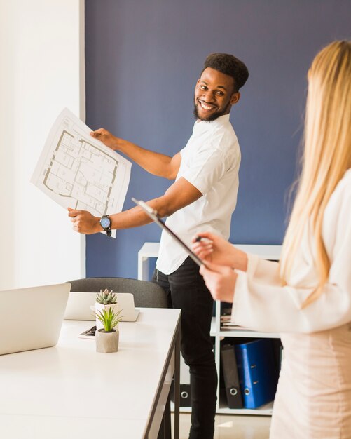 cheerful man showing draft to woman