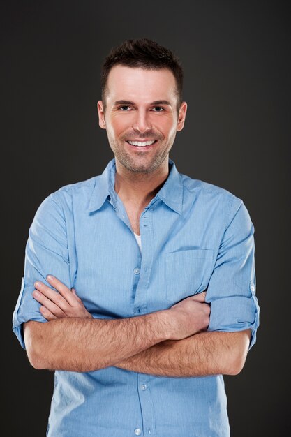 Cheerful man smiling with arms crossed