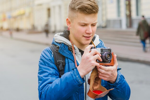 Cheerful man standing with camera