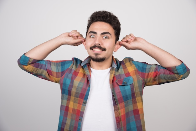 Cheerful man stretch his ears happliy