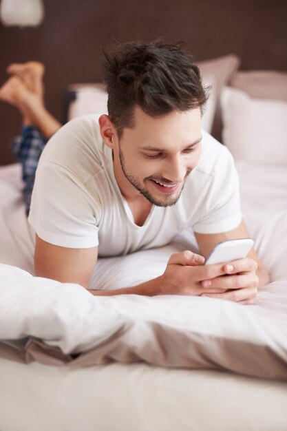 Cheerful man texting with someone funny
