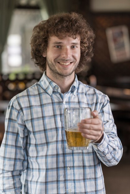 Cheerful man with beer in bar
