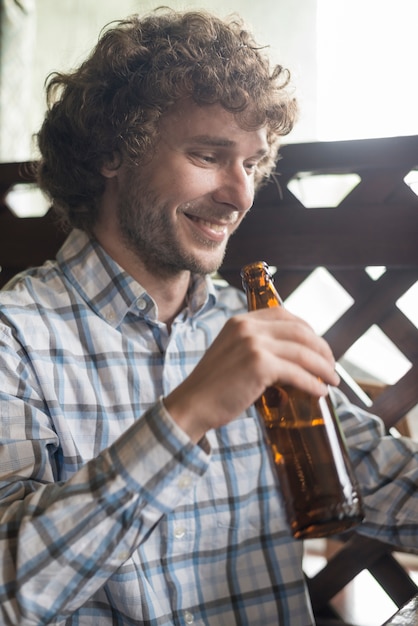Cheerful man with beer in cozy pub