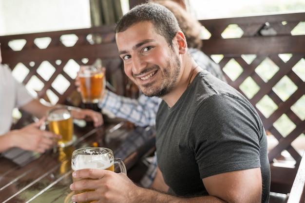 カメラを見てビールと陽気な男