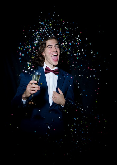 Cheerful man with champagne glass under spangles 