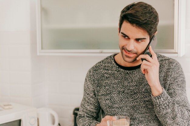 電話で話すカップを持つ明るい男