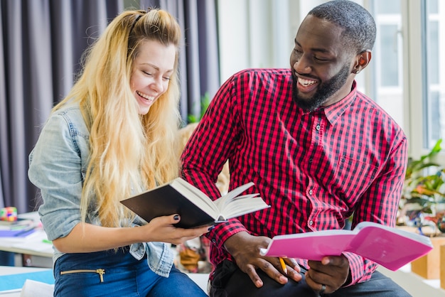 Cheerful man and woman with books