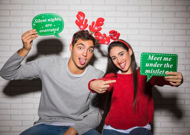 Cheerful man and woman with Christmas hats 