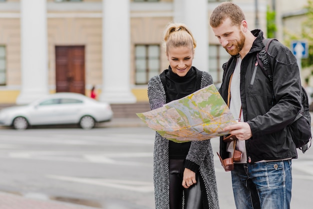 Foto gratuita allegro uomo e donna con la mappa