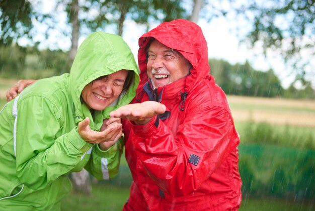 Cheerful married having a fun in rain