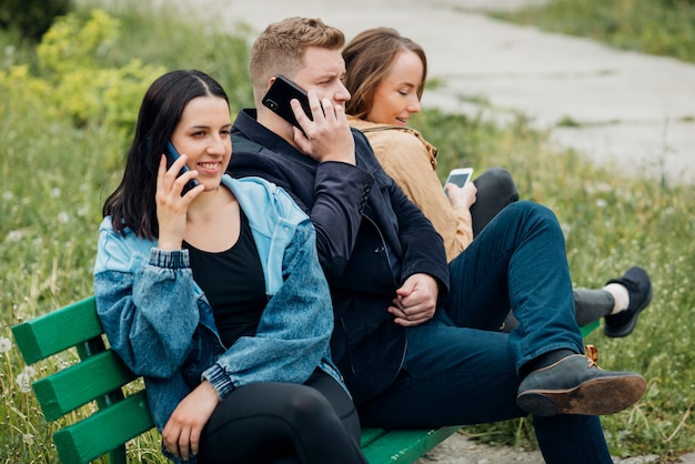 Cheerful mates chilling on bench in park