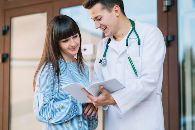 Cheerful medic and patient with papers