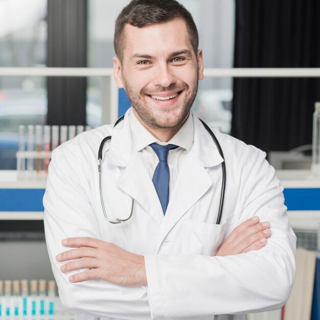 Cheerful medic standing with arms crossed