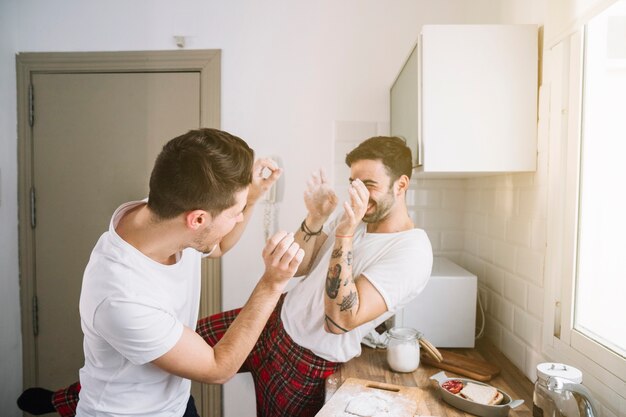 Cheerful men having fun in kitchen