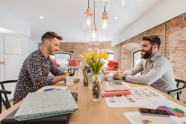 Cheerful men working in office