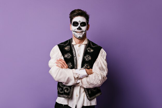 Cheerful Mexican in traditional dress is smiling. Portrait of man on lilac wall.