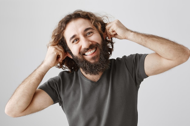 Free photo cheerful middle-eastern man pulling ears playful, mocking someone