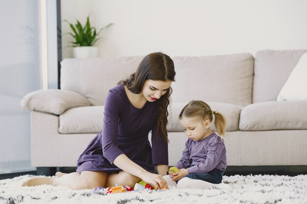 Cheerful  mom playing laughing with little kid daughter