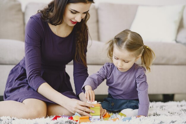 Cheerful  mom playing laughing with little kid daughter