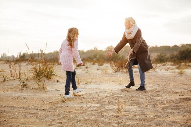 Cheerful mother having fun with her little daughter