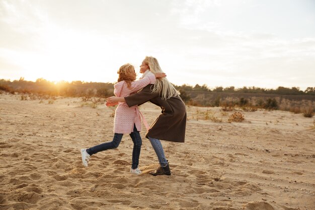 Cheerful mother playing with her little daughter