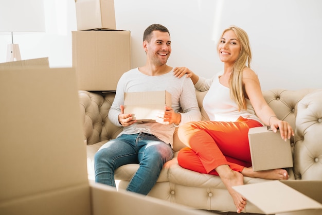 Cheerful moved couple in boxes