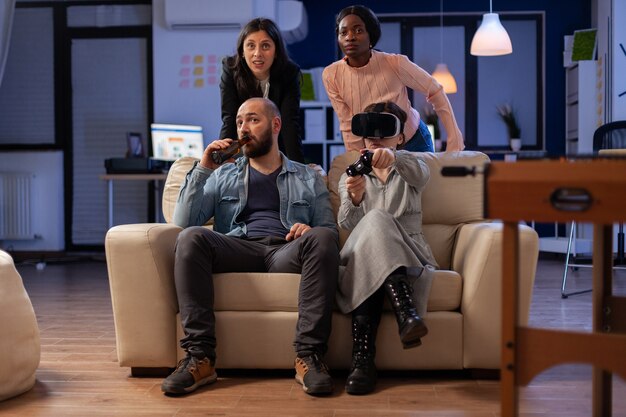 Cheerful multi ethnic friends enjoy vr glasses experience after work