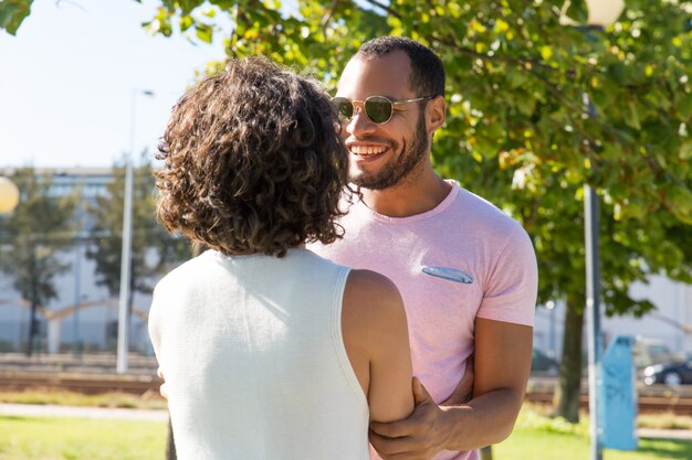 Cheerful multiethnic friends holding hands in park