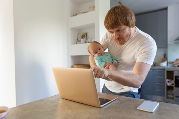 Cheerful new dad holding baby daughter