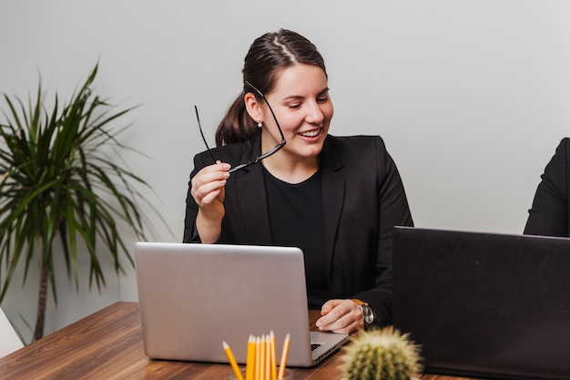 Free photo cheerful office employee holding glasses