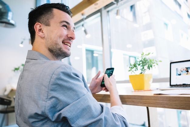 Cheerful office worker with phone