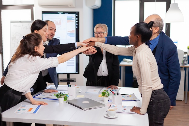 Cheerful overjoyed business people in conference room celerating Diverse colleagues with new opportunity enjoing victory meeting in broadroom office